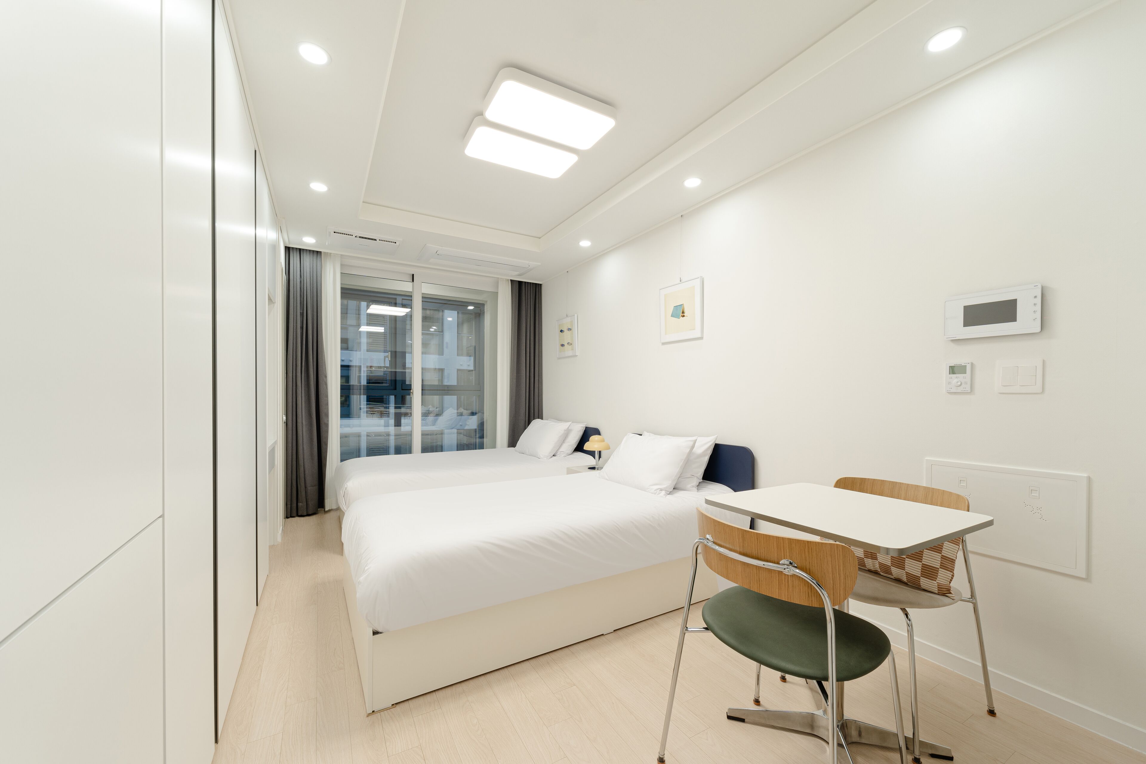 A modern hotel room with a large bed, a desk, and a chair.