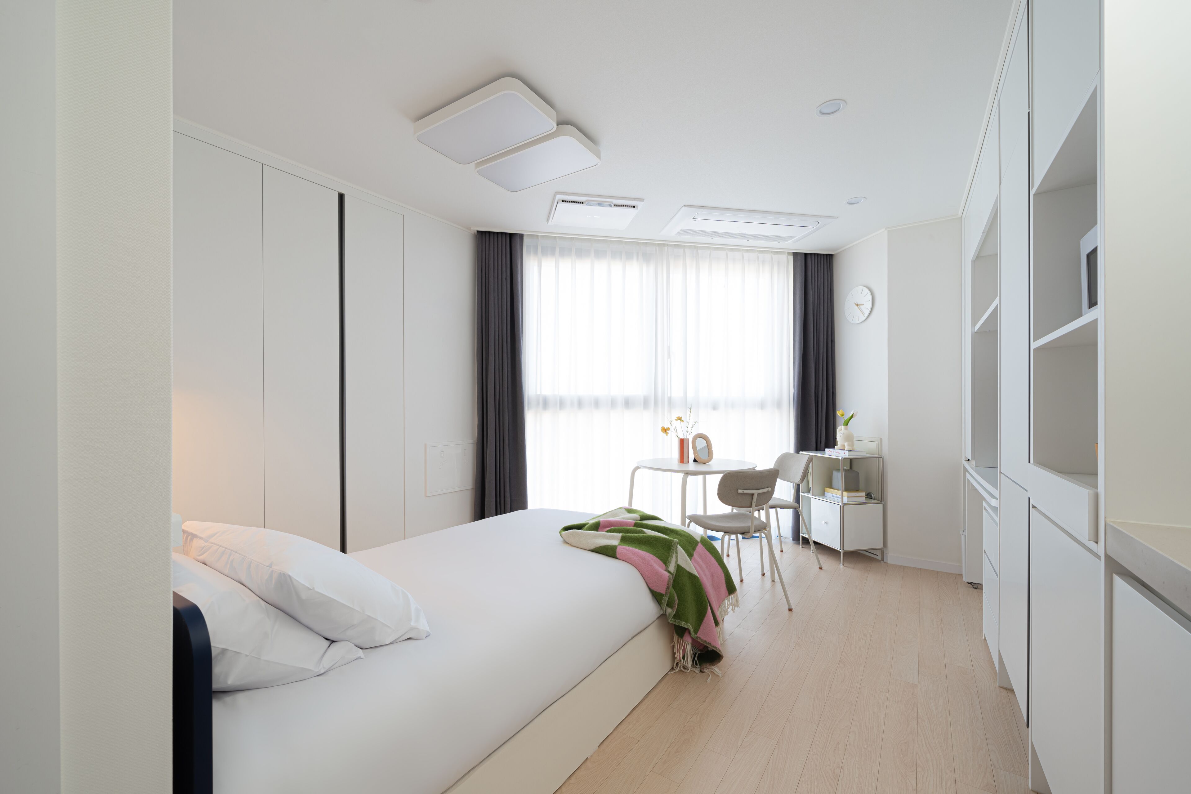 Une chambre d’hôtel moderne, équipée d’un lit, d’un bureau et d’une chaise.