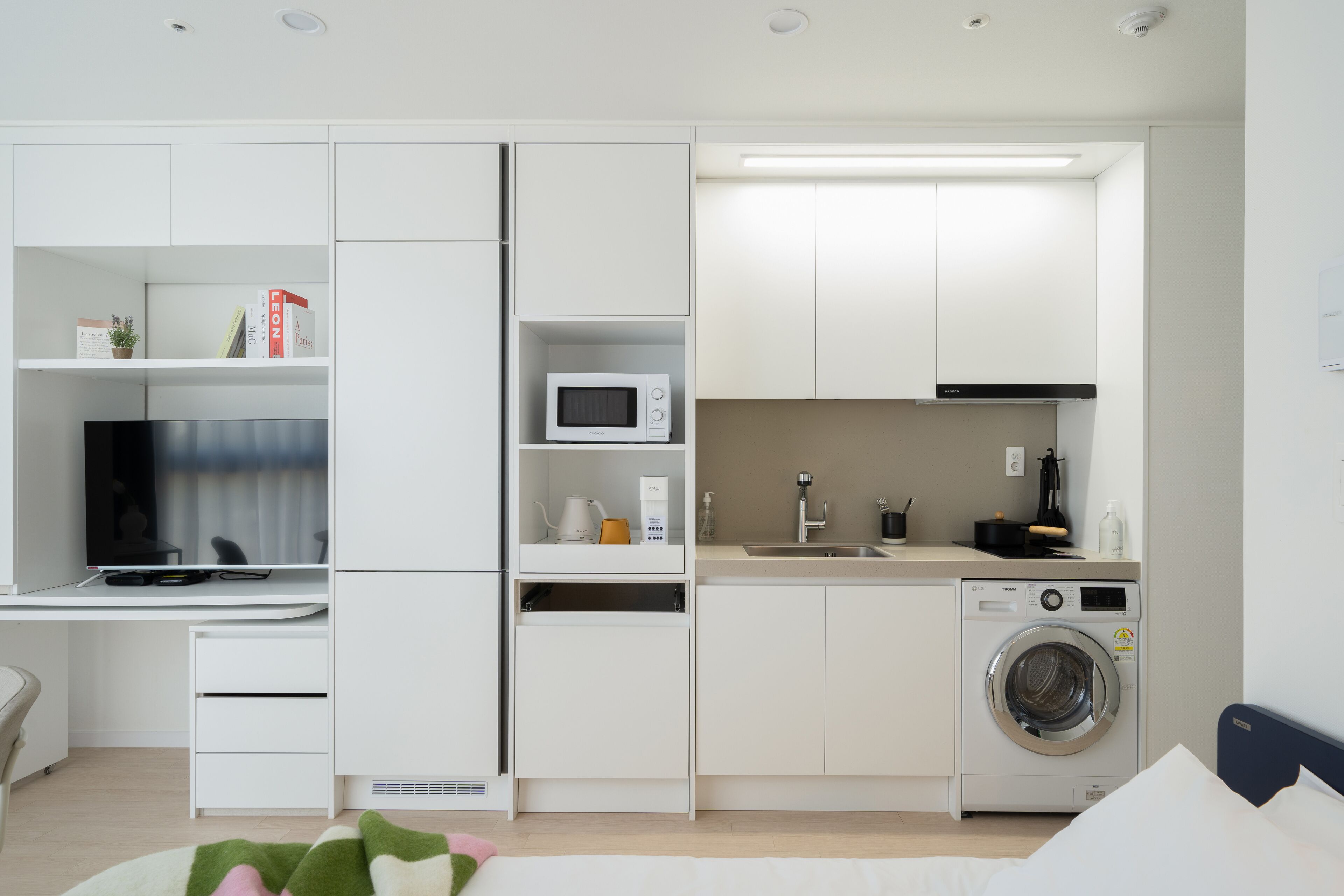 Una kitchenette moderna y funcional, equipada con microondas, cafetera y lavadora.