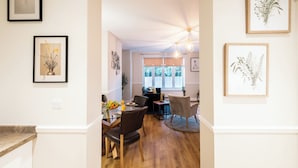 A dining area with a wooden table, chairs, and a window with natural light. - Seymour  (Southampton)