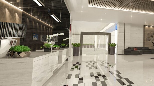 Un hall d’entrée moderne avec un sol à carreaux, des plantes en pot, un comptoir d’accueil et un espace salon.