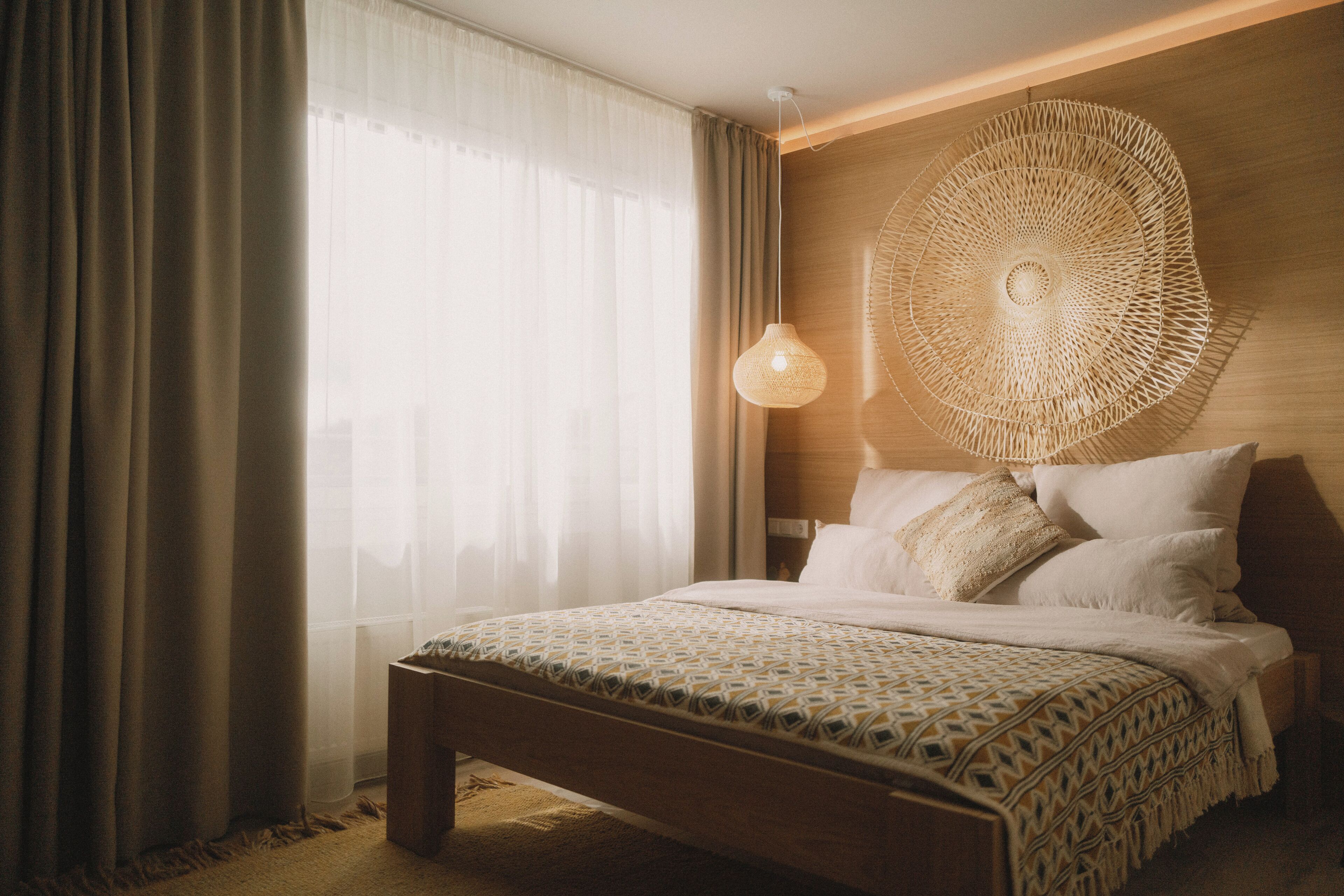 Un dormitorio con una cama grande, una lámpara colgante y un cabecero de madera.