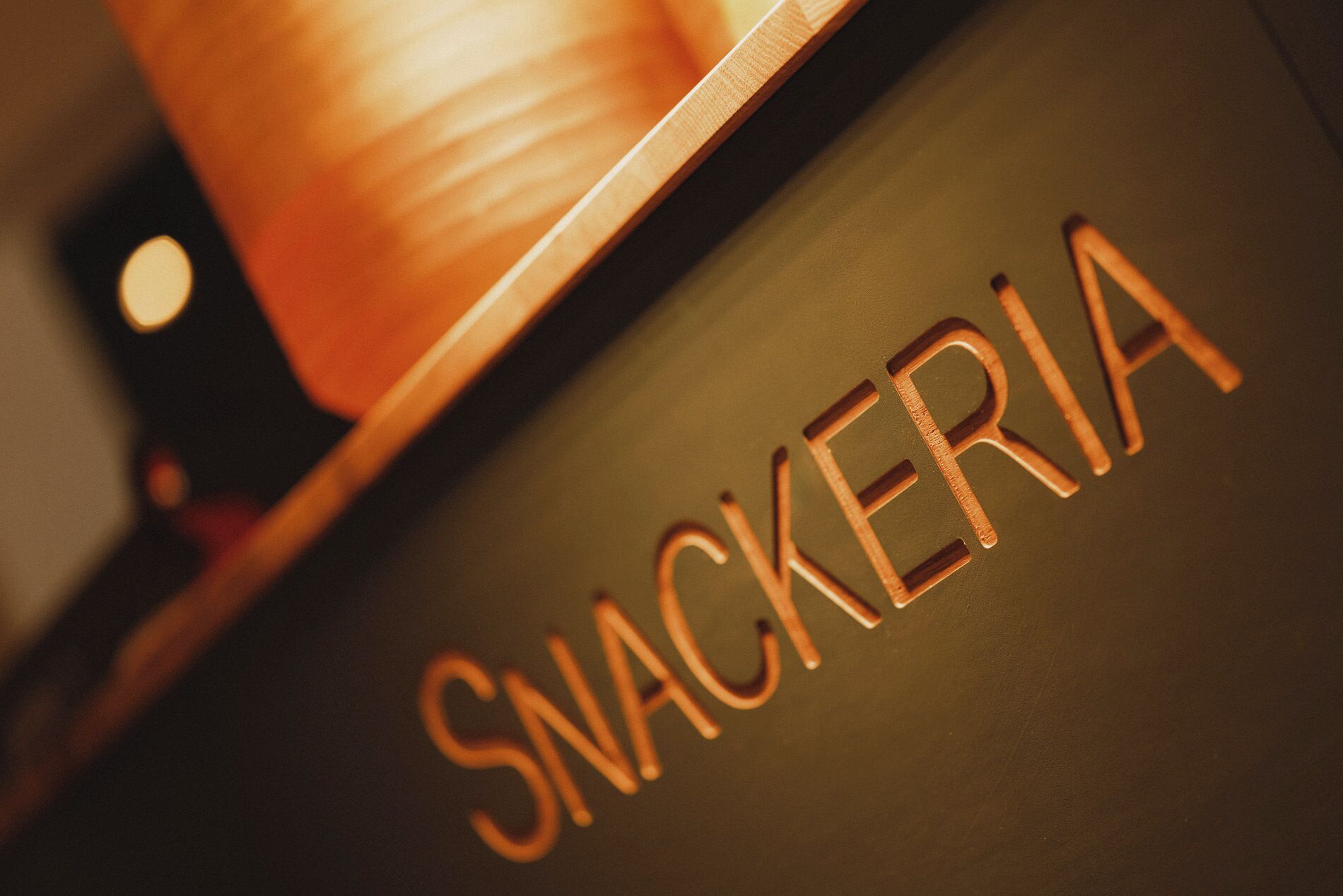 A close-up of a Snackeria sign on a dark surface.