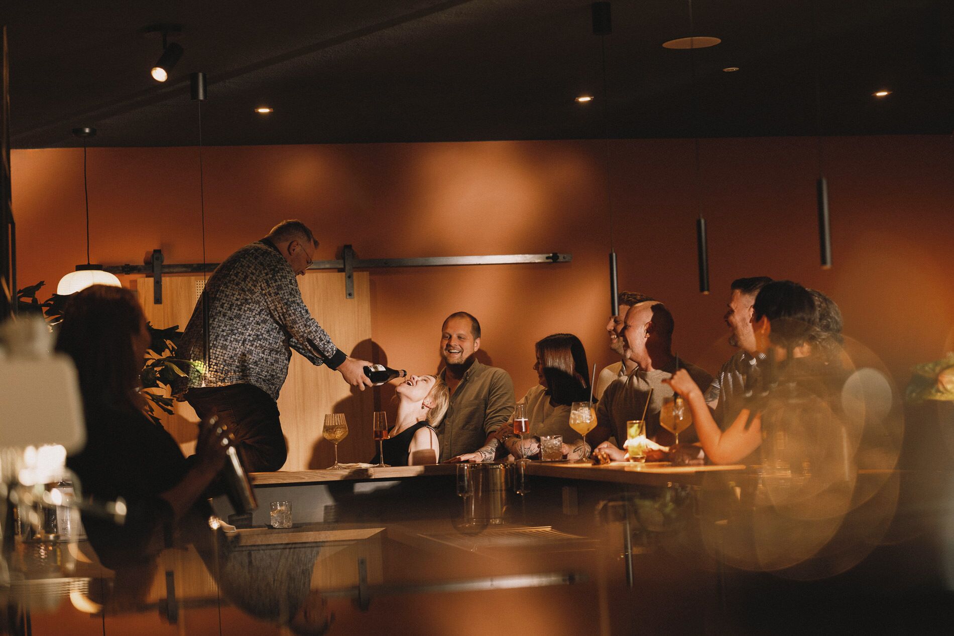 A group of people seated at a table in a dimly lit restaurant with a warm ambiance.