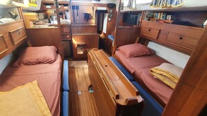 Une cabine compacte et bien aménagée, comprenant deux lits, une petite kitchenette et un coin salon.