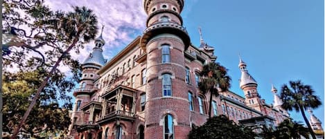A large, historic building with multiple domed towers and a brick facade.