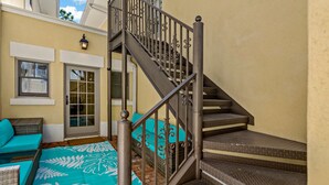 Eine Treppe mit Metallgeländer, die zu einem Balkon führt.