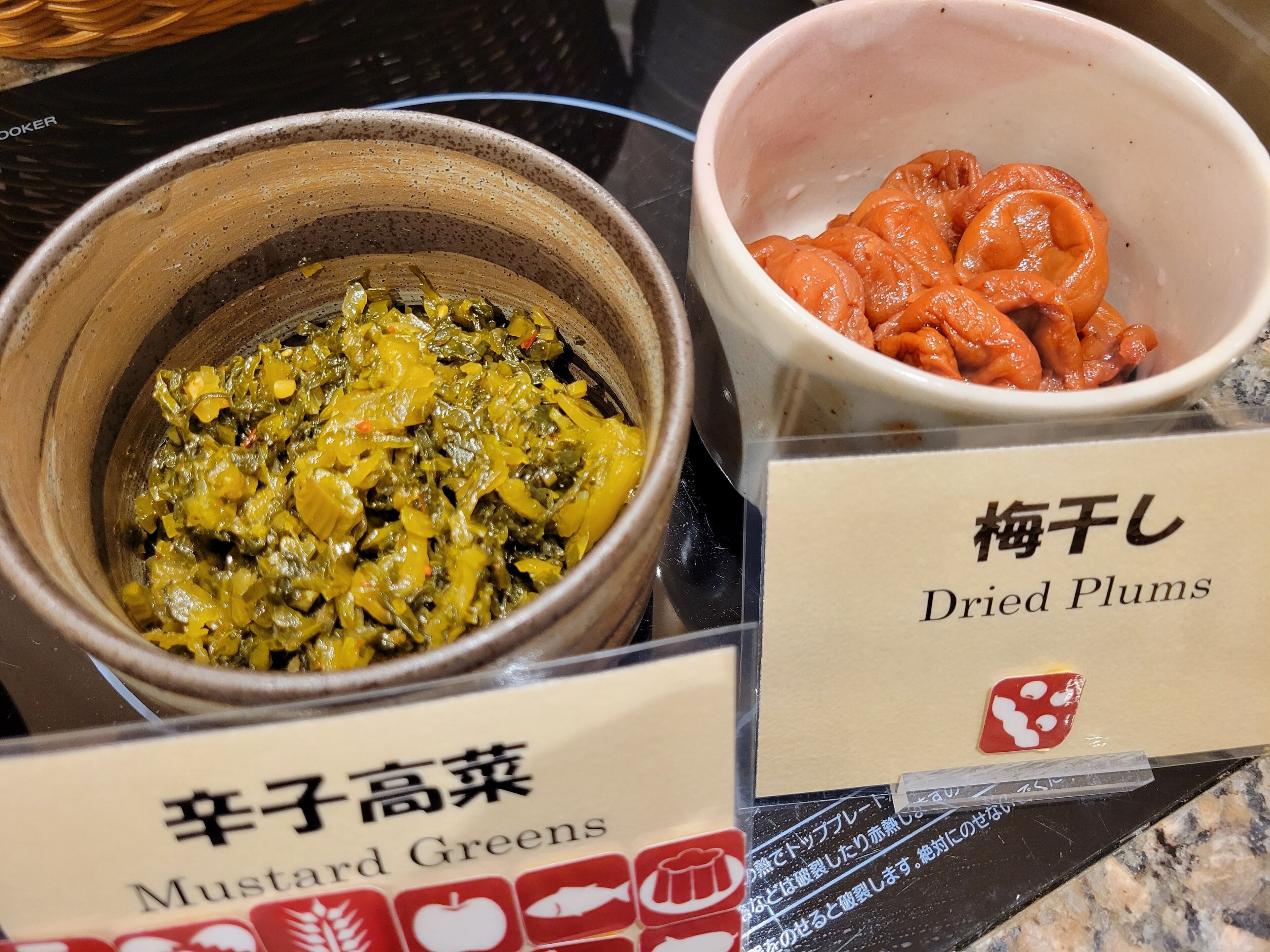 Two bowls of food, one labeled 'Mustard Greens' and the other 'Dried Plums'.