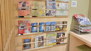 Een presentatie van reisbrochures en kaarten op planken.