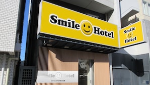 Een Smile Hotel met een geel bord waarop een lachend gezicht staat.