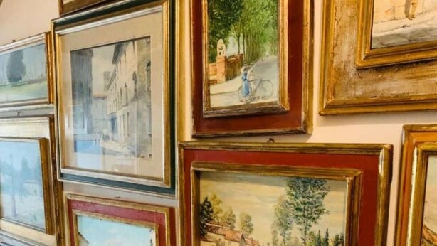 A staircase with multiple framed artworks on the walls. - Eno 's house (Lucca)