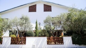 A white building with two triangular windows and a cross on the roof. - Eno 's house (Lucca)