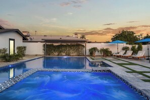 A rectangular swimming pool with a tiled border, surrounded by a white wall and a hedge. - Montecito Luxe: 3-Villa Retreat w/ Pool Courtyard (Phoenix)