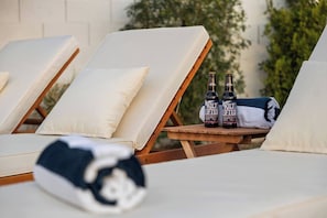 A lounge area with reclining chairs, a blanket, and two bottles of beer. - Montecito Luxe: 3-Villa Retreat w/ Pool Courtyard (Phoenix)