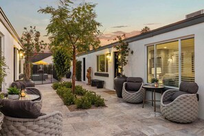 A patio area with outdoor seating, a small table, and a potted plant.