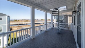 A covered porch with a view of a water body and distant landscape. - Coastal Comfort: 4BR 3BH House Pool & Rooftop Deck (Selbyville)