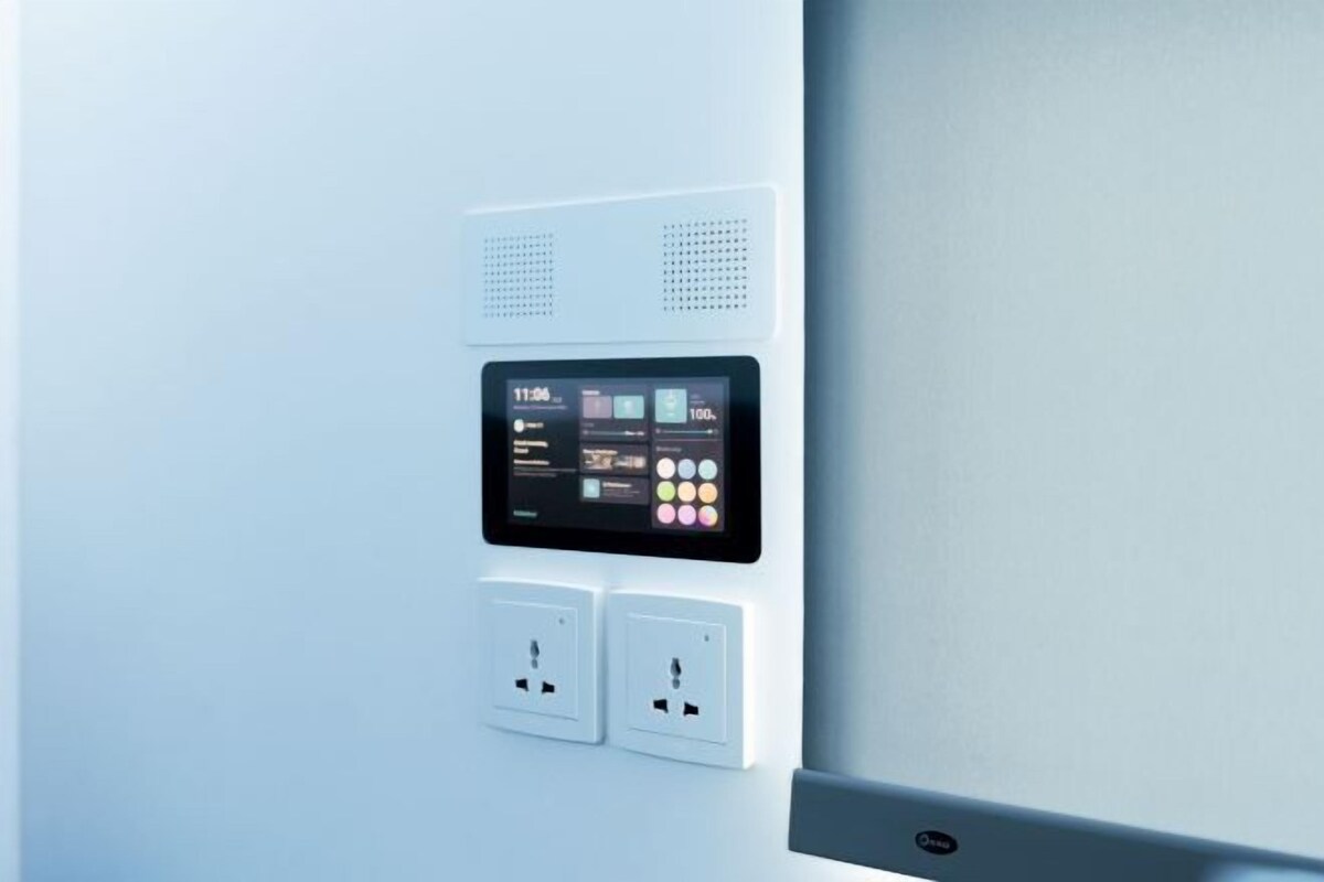 En väggmonterad kontrollpanel med en digital display och två eluttag.