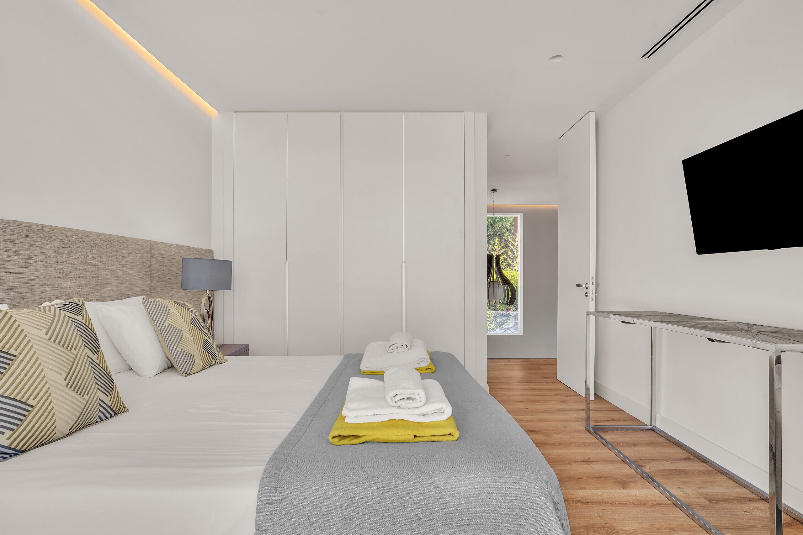 Une chambre d’hôtel moderne équipée d’un lit, d’un bureau et d’une télévision.