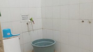 Ett litet badrum med en toalett, ett blått handfat och en skylt på väggen.