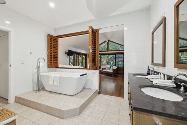 A modern bathroom with a freestanding bathtub, a vanity with a sink, and a large mirror. - Beached - Beach is your Back Yard, Pet Friendly (Sawtell)