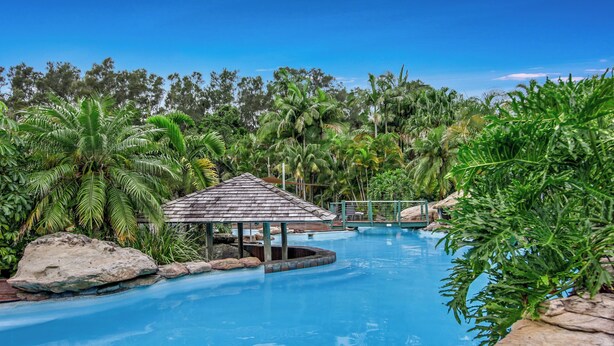 A pool surrounded by tropical vegetation and a small gazebo. - Cuttlefish Cove - 2BR Resort Living by Diggers Beach (Coffs Harbour)