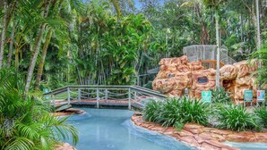A water slide with a bridge, surrounded by tropical vegetation. - Oceanique - 3BR Tranquil Retreat by Diggers Beach (Coffs Harbour)
