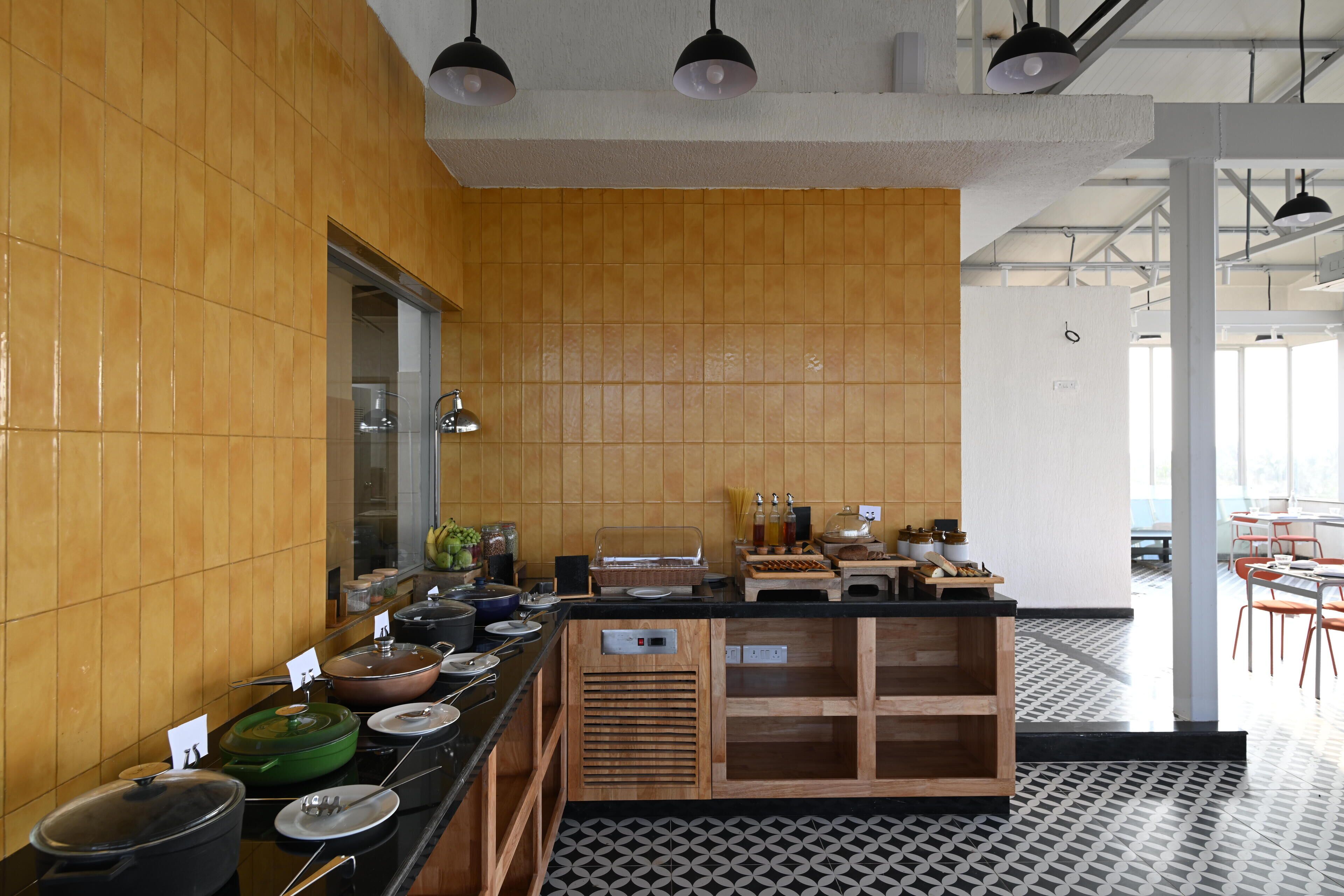 A modern kitchen with wooden cabinets, a black countertop, and various cooking appliances.
