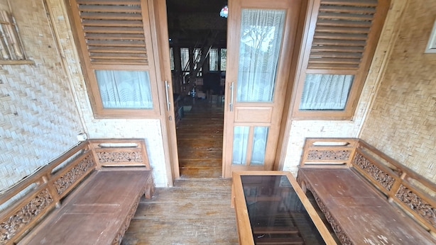 A wooden staircase leading to a room with a woven ceiling and a large window. - OYO 93656 Villa Cassanova Syariah (Garut)