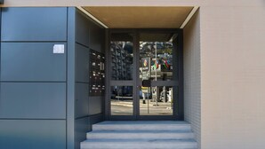 A building entrance with a set of steps leading up to a glass door. - Central Plaza Apartment 3 in Lugano (Lugano)