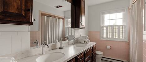 Hallway bathroom with tub/shower and double vanity