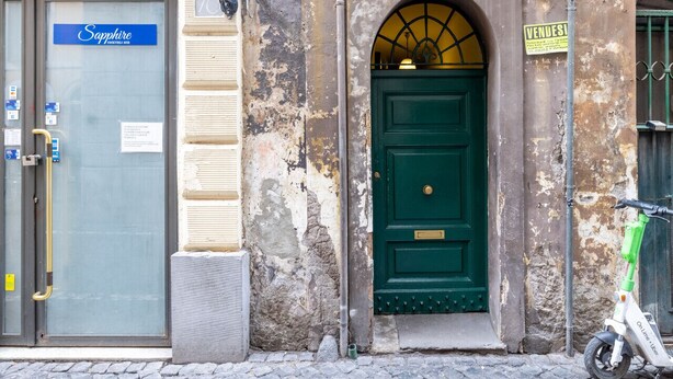 A building with a green door, a sign for 'Sapphire' on the left, and a 'VENDESI' sign on the right. - Cozy Love Nest Steps from Colosseum (Roma)