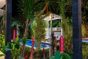 A pool area with a gazebo, surrounded by lush greenery and red plants. - Belvilla Ananda Resort Lovina BeachNearPantai Lovina (Buleleng)
