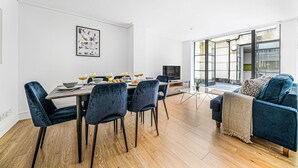 Ein modernes Wohnzimmer mit Essbereich, einer Couch und einem Fernseher.