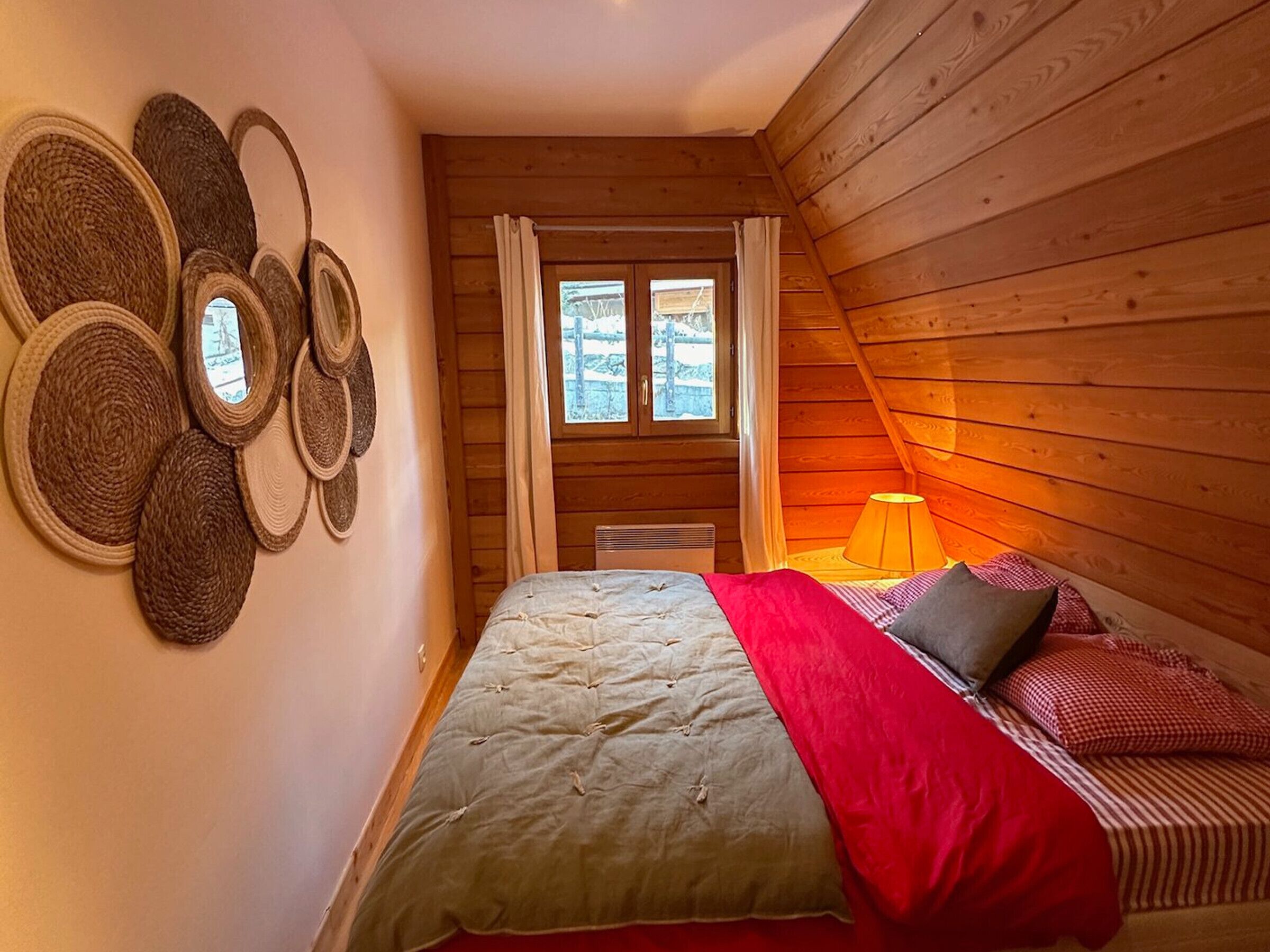 Um quarto aconchegante com uma cama, uma janela e um abajur.