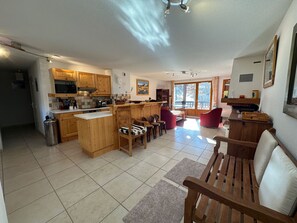 Relax in a spacious living area with a central kitchen island, comfortable seating, and large window.