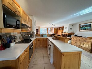 Enjoy cooking in this well-equipped kitchen with a central island, microwave, oven, and washing machine.