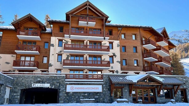 A multi-story hotel with wooden balconies and a stone facade. - Bright ski-in/ski-out apartment with balcony in Vars Les Claux (Vars)