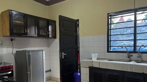 Una cocina con refrigerador, estufa y alacenas.