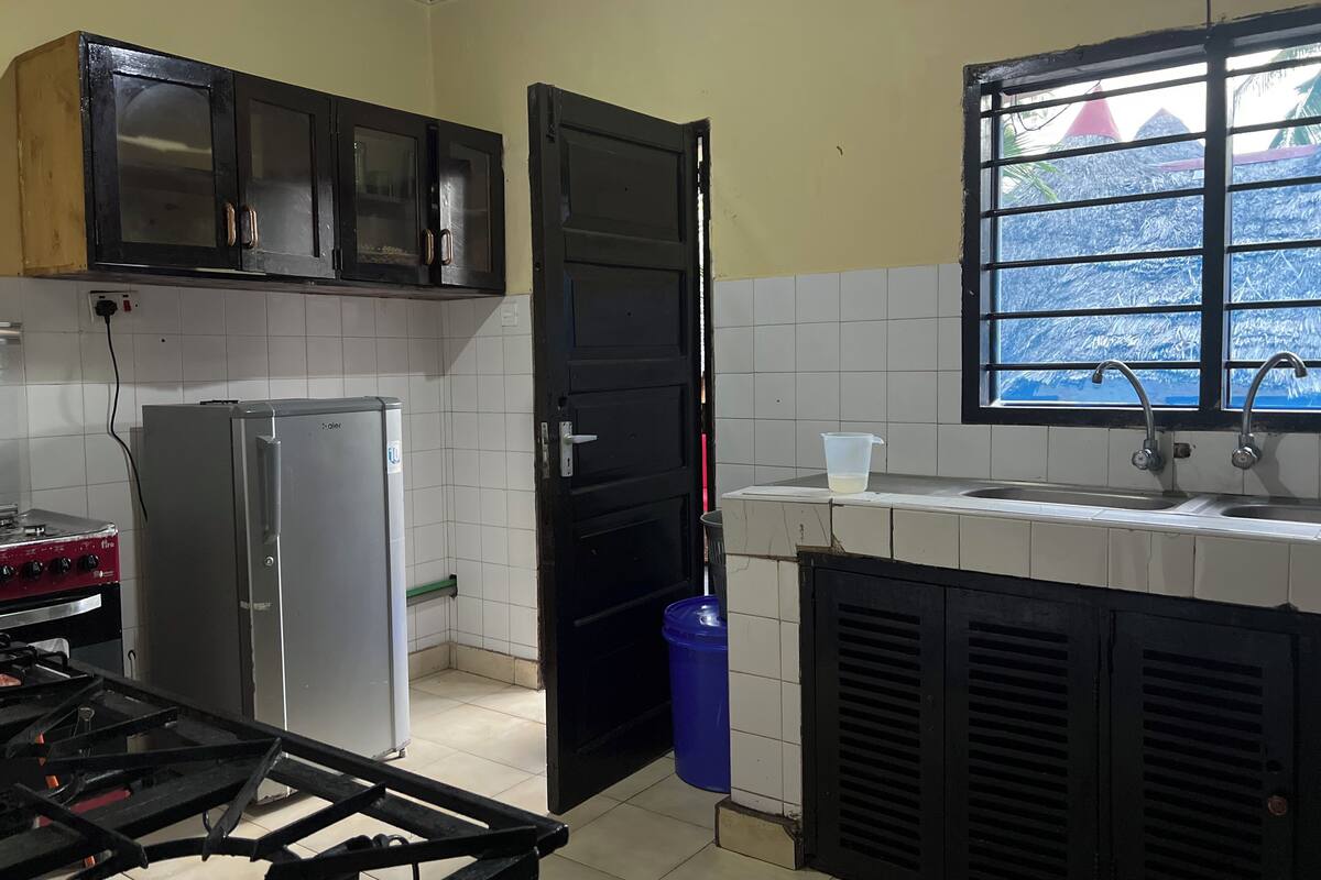 A kitchen with a refrigerator, stove, and cabinets.