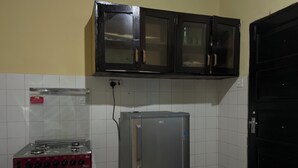 Una cocina con estufa a gas, refrigerador y armarios sobre la encimera.