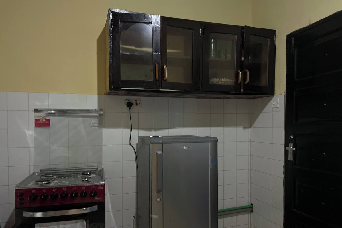 A kitchen with a gas stove, a refrigerator, and cabinets above the counter.