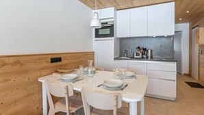 A modern kitchen with white cabinets, a built-in oven, and a stainless steel sink. - Val d'Isère: Renovated 1-Bed Apartment, Ski-In/Ski-Out, Sleeps 4, Stunning Mountain Views (Val-d'Isère)