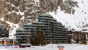 A multi-story hotel with balconies, situated in a snowy mountainous area. - Val d'Isère: Renovated 1-Bed Apartment, Ski-In/Ski-Out, Sleeps 4, Stunning Mountain Views (Val-d'Isère)