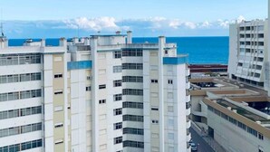 Un edificio de gran altura con varios pisos, ventanas amplias y vista al océano.
