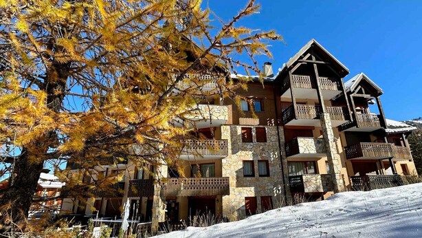 A multi-story building with balconies, stone facade, and a snowy landscape. - Spacious T3 near slopes, south terrace, with WIFI, for 6 people (Vars)