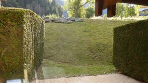 A paved pathway leading to a grassy area with a stone wall and a wooden structure in the background. - 2-room apartment, terrace, pets allowed, Les Contamines-Montjoie (Les Contamines-Montjoie)