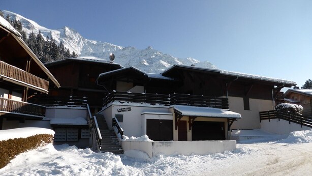 A snow-covered building with a staircase leading to a door, surrounded by snow and mountains in the background. - 2-room apartment, terrace, pets allowed, Les Contamines-Montjoie (Les Contamines-Montjoie)