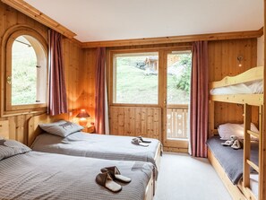 Quarto acolhedor com duas camas, uma janela e vista para o exterior.