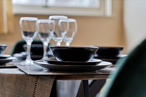 A dining table set with plates, bowls, and wine glasses, suggesting a formal dining setting.