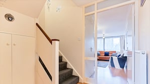 Un escalier menant à un espace de vie comprenant un canapé et un radiateur.